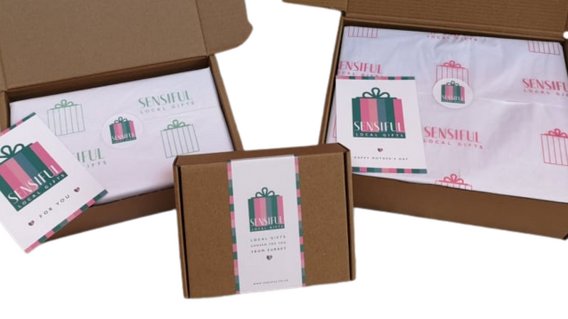Three Sensiful boxes showing how the gifts are wrapped with green and pink customised tissue and sealed with a Sensiful sticker.  Boxes can also include a handwritten card.